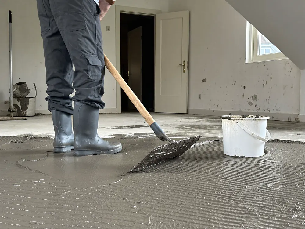 Egaline wordt uitgezet over de betonvloer van een lege kamer