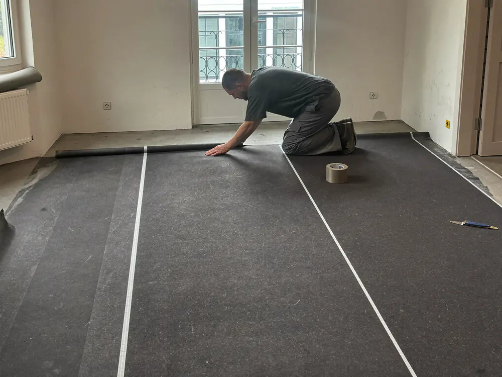 Akoestische ondervloer voor PVC wordt uitgelegd in een appartement