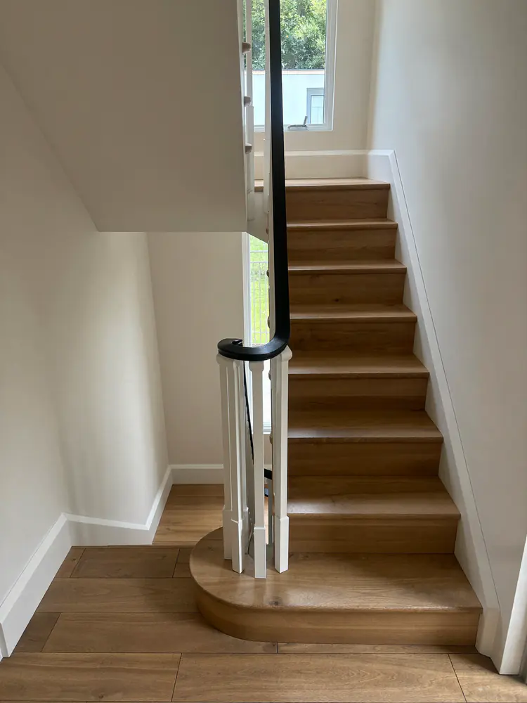 Trap met PVC treden in eikenlook die aansluit op de vloer in de hal
